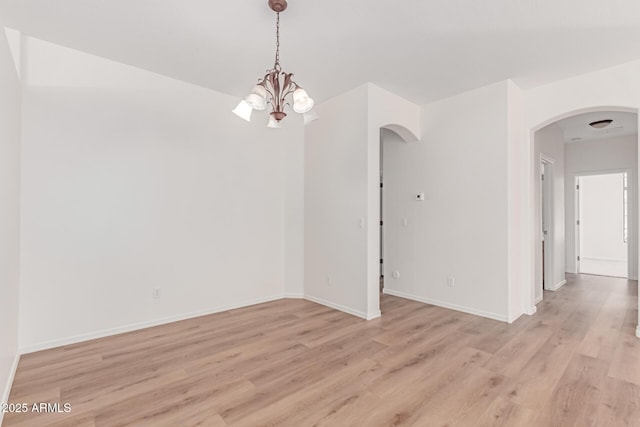 2140 S Benton Cir, Mesa, AZ 85209 - empty room with a chandelier, arched walkways, light wood-style floors, and baseboards