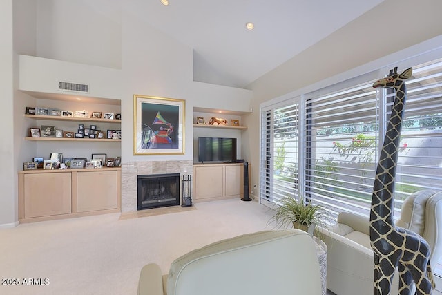 10068 E Cinnabar Ave, Scottsdale, AZ 85258 - living area featuring visible vents, carpet, a tiled fireplace, built in features, and lofted ceiling