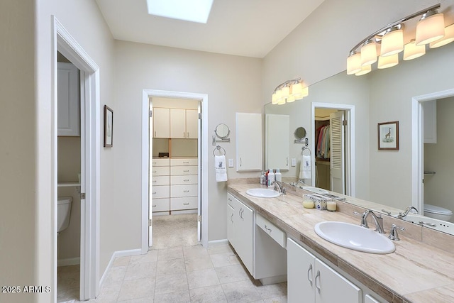 10068 E Cinnabar Ave, Scottsdale, AZ 85258 - bathroom featuring baseboards, double vanity, a sink, and toilet