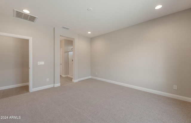 unfurnished bedroom featuring baseboards, recessed lighting, visible vents, and light colored carpet