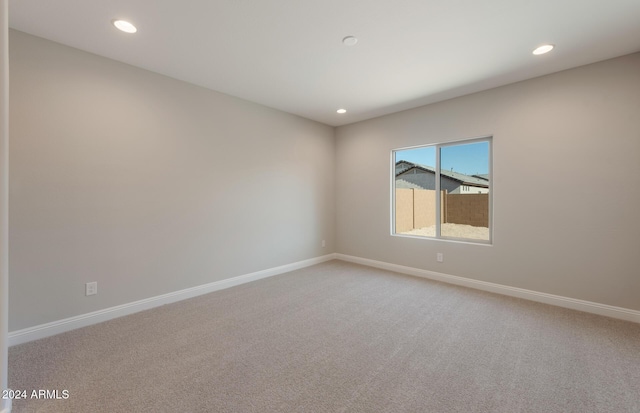 unfurnished room with recessed lighting, light colored carpet, and baseboards