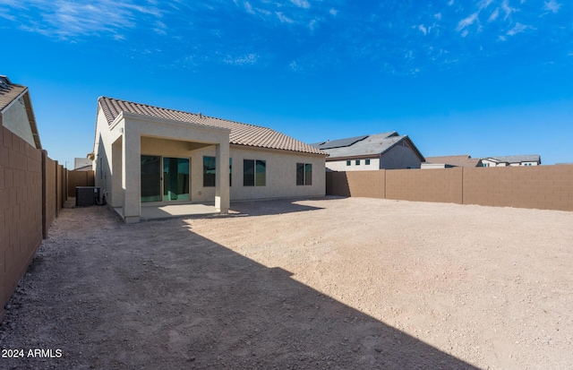 back of property with a tile roof, a patio, stucco siding, central AC unit, and a fenced backyard