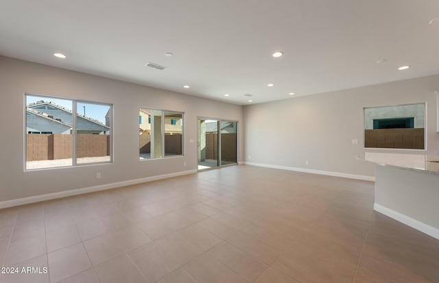 tiled empty room with baseboards, visible vents, and recessed lighting