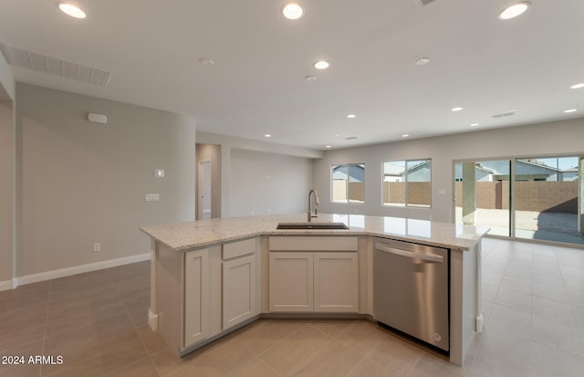 kitchen with a sink, light stone counters, dishwasher, and recessed lighting