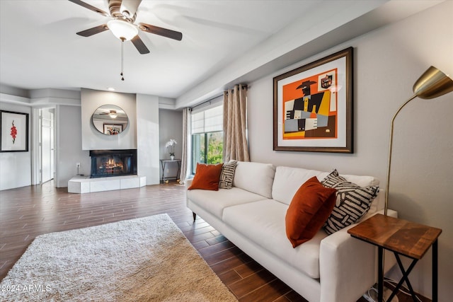 living room featuring a fireplace, dark hardwood / wood-style flooring, and ceiling fan