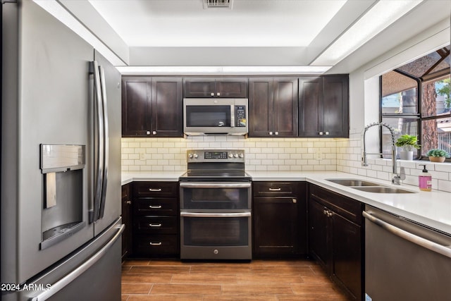 kitchen with light hardwood / wood-style floors, sink, dark brown cabinetry, and stainless steel appliances