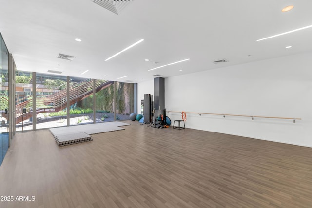 interior space featuring a wall of windows, wood finished floors, and visible vents