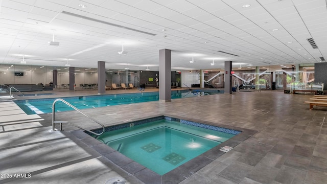 pool with a patio area and an indoor hot tub