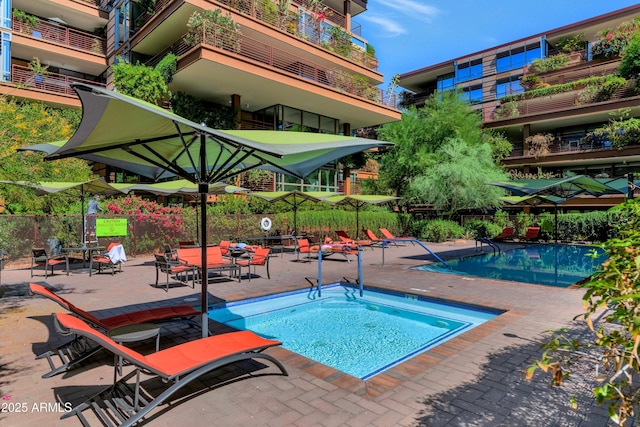 community pool with a patio and fence