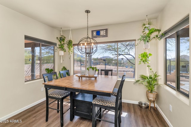 dining room featuring a chandelier, wood finished floors, and baseboards