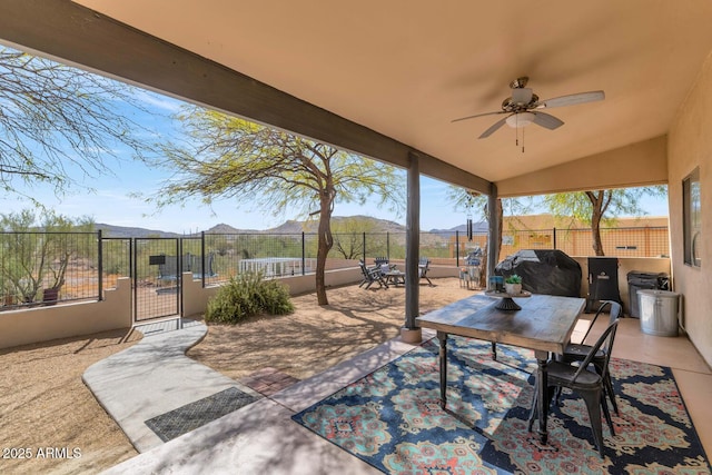 view of patio featuring a grill, outdoor dining area, a fenced backyard, and a mountain view