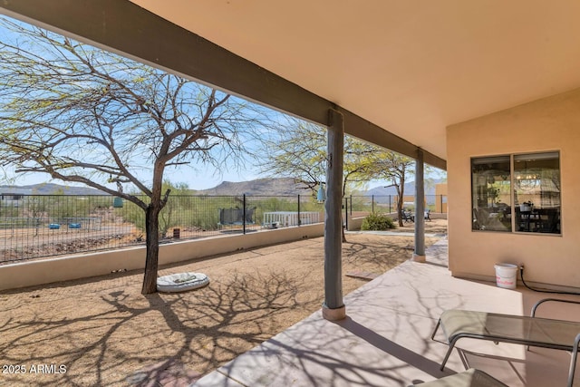 view of patio featuring fence and a mountain view