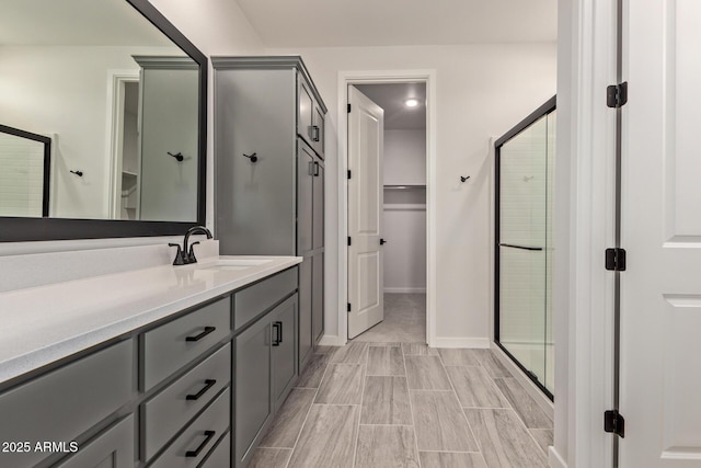 bathroom with a shower with shower door and vanity