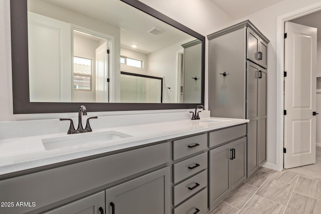 bathroom featuring a shower with door and vanity