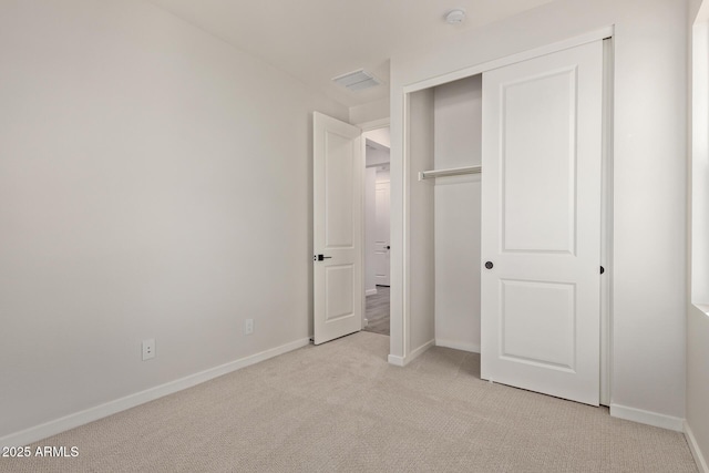 unfurnished bedroom featuring a closet and light carpet