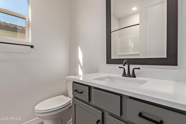 bathroom featuring walk in shower, vanity, and toilet