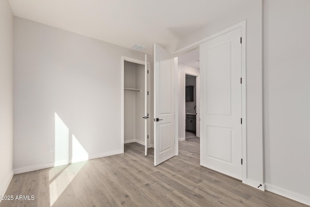 unfurnished bedroom featuring a closet and light hardwood / wood-style flooring