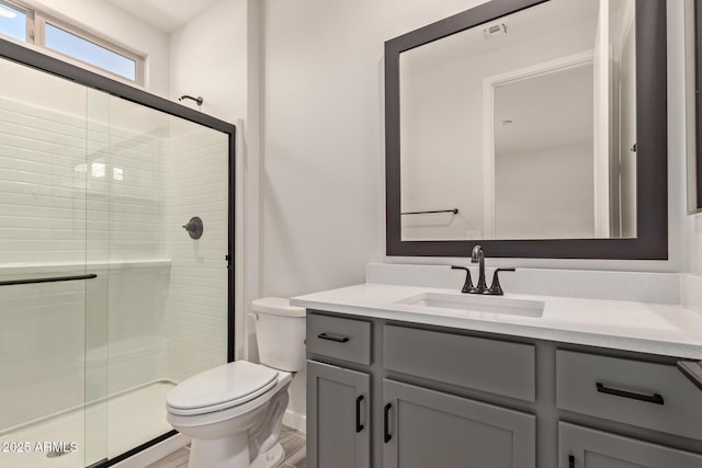 bathroom with toilet, wood-type flooring, vanity, and walk in shower