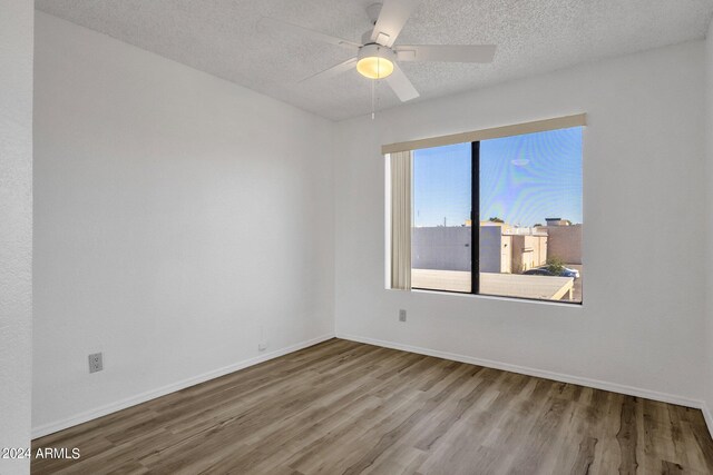 unfurnished room featuring light hardwood / wood-style floors, a textured ceiling, a wealth of natural light, and ceiling fan