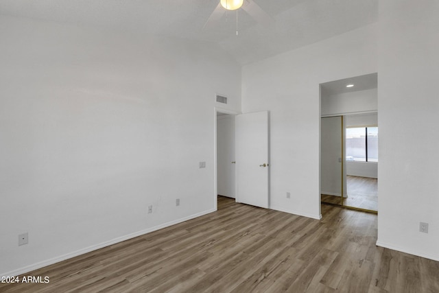 unfurnished bedroom with light hardwood / wood-style floors, high vaulted ceiling, and ceiling fan