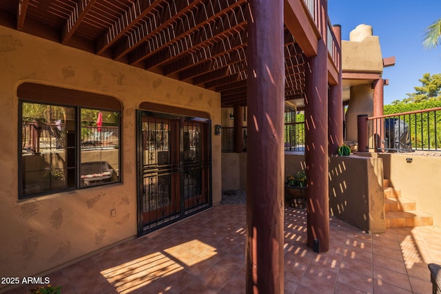 view of exterior entry featuring a patio and stucco siding