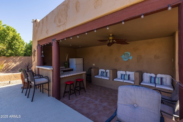 view of patio / terrace featuring fence, outdoor dry bar, and a ceiling fan