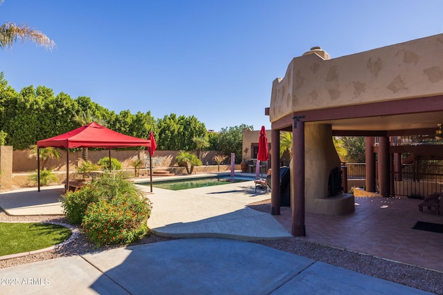 exterior space with a patio, a gazebo, a fenced backyard, and a pool