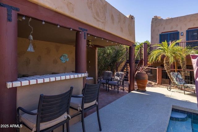 view of patio / terrace with ceiling fan and stairway