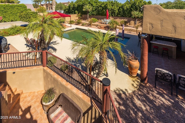 view of pool featuring a patio, fence, and stairway
