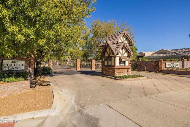view of front facade featuring brick siding, fence, and a gate