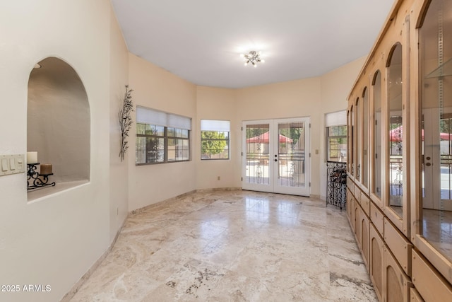 spare room with baseboards and french doors