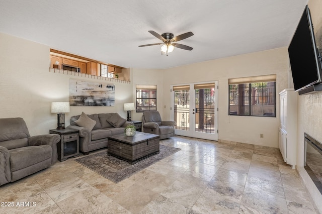 living room featuring ceiling fan and stone finish flooring