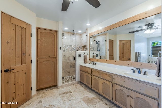 full bath featuring double vanity, a sink, ceiling fan, and a stall shower