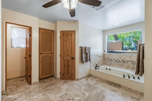 bathroom with visible vents, a ceiling fan, baseboards, and a garden tub