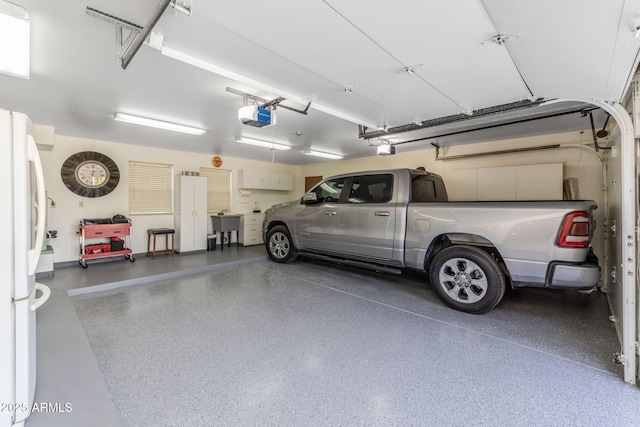garage featuring a garage door opener and freestanding refrigerator