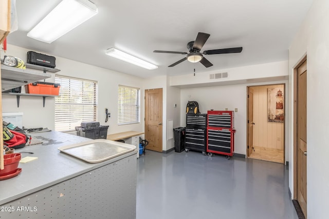 office area featuring concrete flooring, a ceiling fan, and visible vents