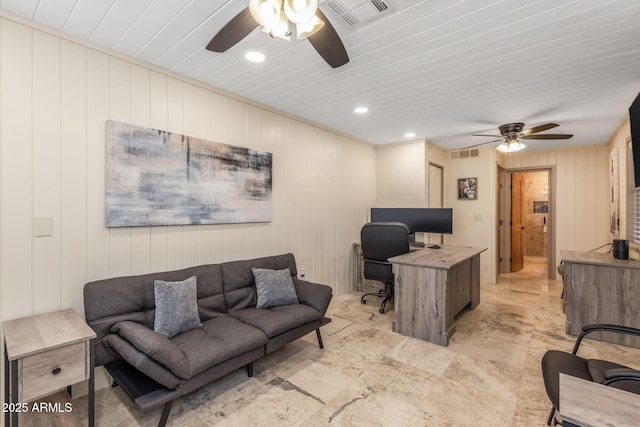 office featuring ceiling fan, visible vents, and wood walls