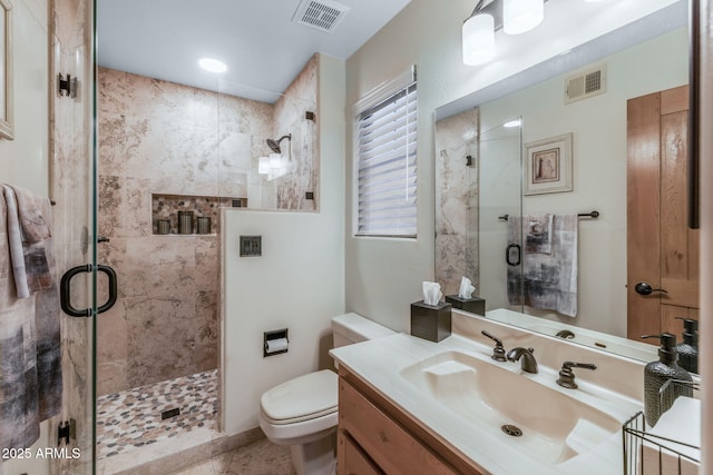 full bathroom featuring visible vents, vanity, toilet, and a shower stall