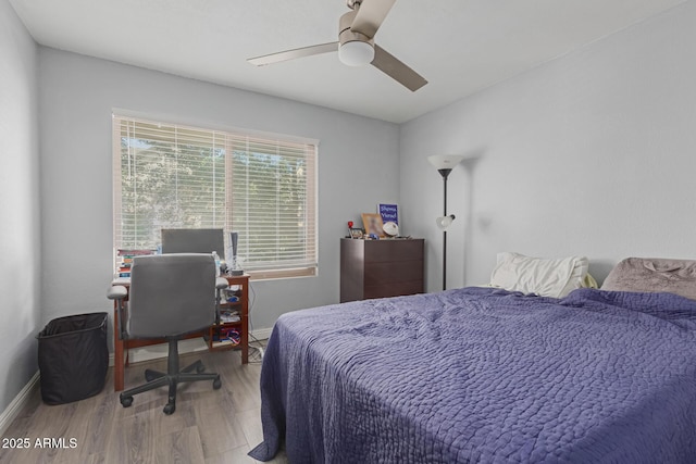 bedroom with a ceiling fan, baseboards, and wood finished floors