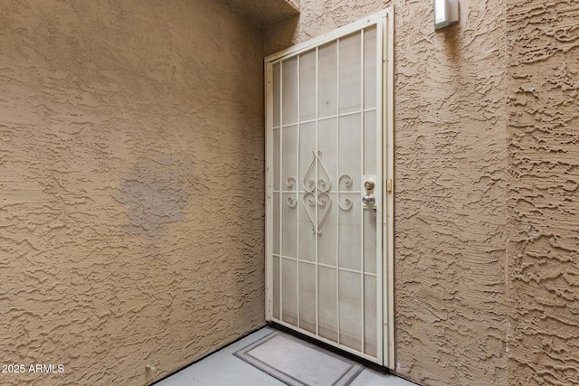 doorway to property featuring stucco siding