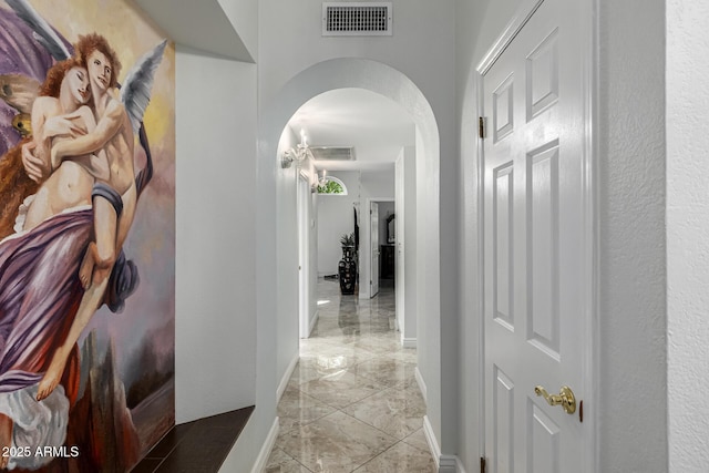 6941 W Voltaire Ave, Peoria, AZ 85381 - corridor with arched walkways, light marble finish floors, and baseboards