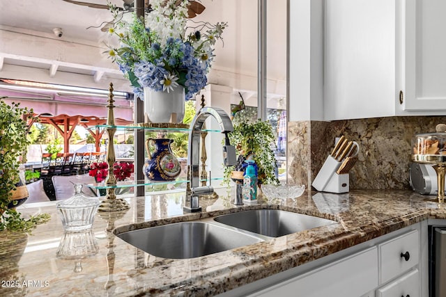 6941 W Voltaire Ave, Peoria, AZ 85381 - kitchen featuring a sink, white cabinets, tasteful backsplash, and light stone countertops