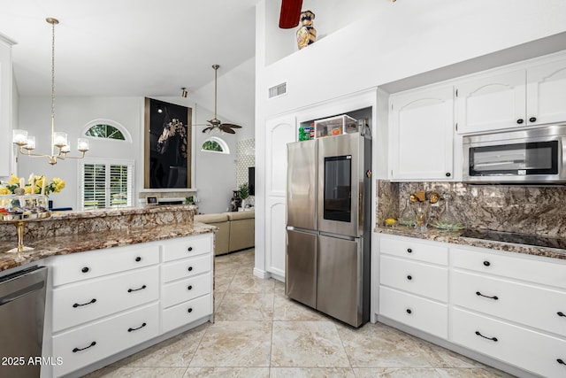 6941 W Voltaire Ave, Peoria, AZ 85381 - kitchen with stainless steel appliances, a chandelier, dark stone countertops, white cabinetry, and high vaulted ceiling