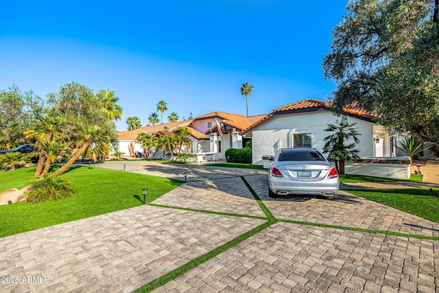 6941 W Voltaire Ave, Peoria, AZ 85381 - mediterranean / spanish-style home with a tiled roof, a front lawn, curved driveway, and stucco siding