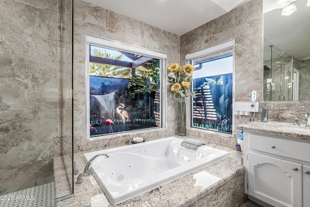 6941 W Voltaire Ave, Peoria, AZ 85381 - full bathroom featuring a stall shower, vanity, a jetted tub, and tile walls