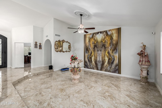 6941 W Voltaire Ave, Peoria, AZ 85381 - unfurnished living room with arched walkways, vaulted ceiling, a ceiling fan, marble tiled flooring, and baseboards