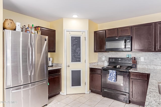 kitchen featuring decorative backsplash, light tile patterned flooring, dark brown cabinetry, and black appliances