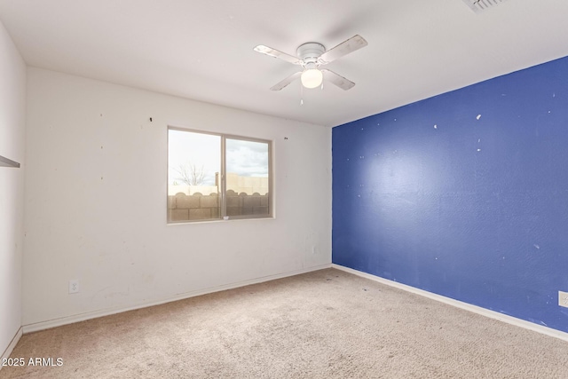 carpeted spare room with ceiling fan and baseboards