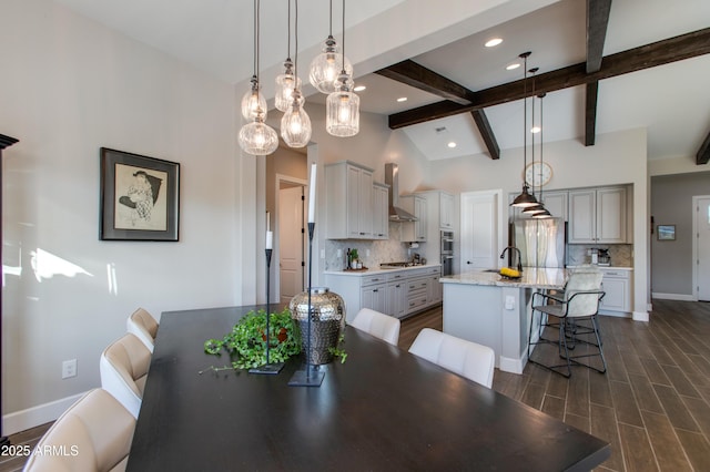 dining room featuring lofted ceiling with beams and sink