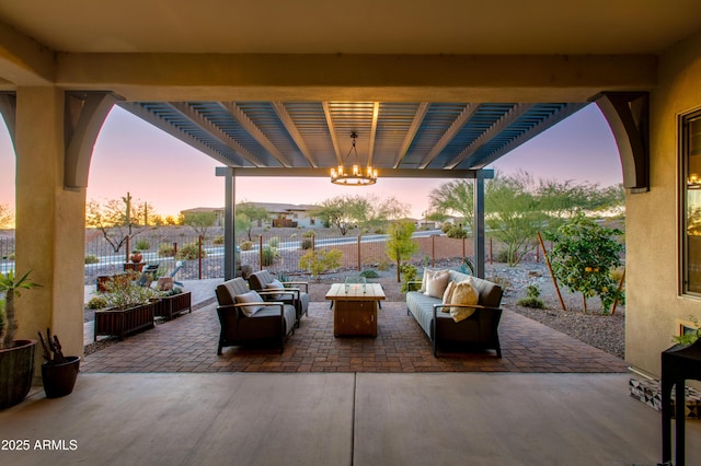 patio terrace at dusk with a pergola and an outdoor living space with a fire pit